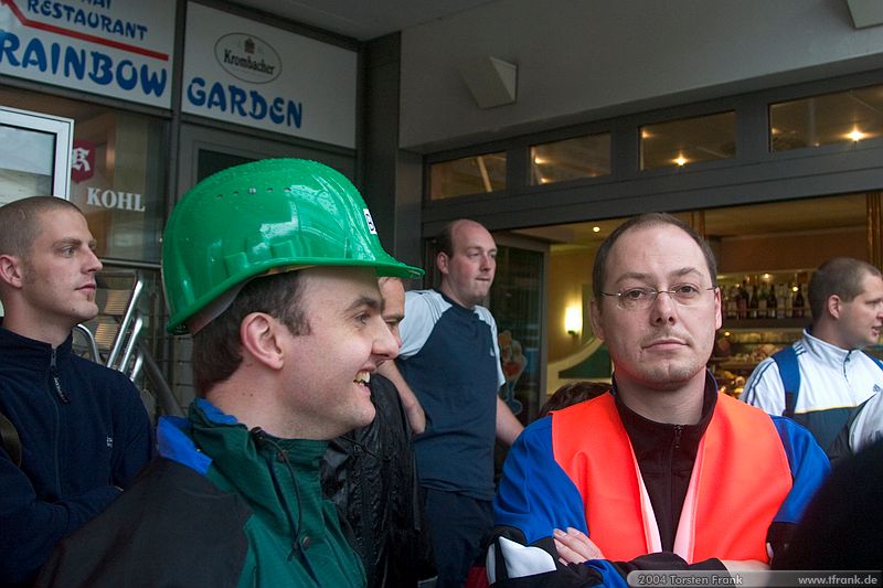 Jörg Wieland und Volker Spieß, Team "BaUnis - Das Team vom Bau!". Treffpunkt vor dem Lauf.\n1. Siegerländer AOK – Firmenlauf am 9. Juli 2004 in der Siegener Innenstadt über 5,5 km mit über 2200 gemeldeten Teilnehmern. Die Witterungsbedingungen mit teilweise strömenden Regen und zurückhaltenden Temperaturen waren leider nicht dem sommerlichen Datum angemessen, was der Lauffreude jedoch keinen Abbruch tat.