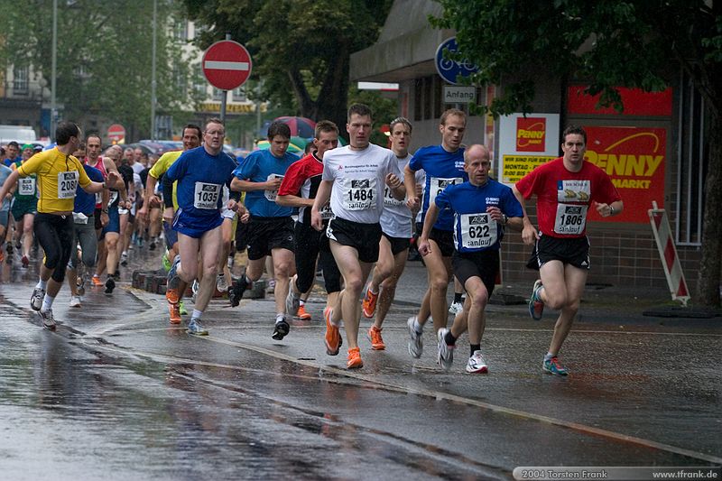 Die Spitze der Läuferschar kurz nach dem Start.\n1. Siegerländer AOK – Firmenlauf am 9. Juli 2004 in der Siegener Innenstadt über 5,5 km mit über 2200 gemeldeten Teilnehmern. Die Witterungsbedingungen mit teilweise strömenden Regen und zurückhaltenden Temperaturen waren leider nicht dem sommerlichen Datum angemessen, was der Lauffreude jedoch keinen Abbruch tat.