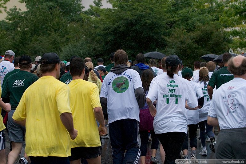 Impressionen des Teilnehmerfeldes, wie es um die erste Kurve auf die Hindenburgstraße einbiegt.\n1. Siegerländer AOK – Firmenlauf am 9. Juli 2004 in der Siegener Innenstadt über 5,5 km mit über 2200 gemeldeten Teilnehmern. Die Witterungsbedingungen mit teilweise strömenden Regen und zurückhaltenden Temperaturen waren leider nicht dem sommerlichen Datum angemessen, was der Lauffreude jedoch keinen Abbruch tat.