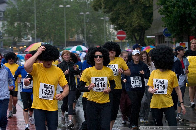 Laufteilnehmer der Gemeinde Neunkirchen, Team "Irrläufer"\n1. Siegerländer AOK – Firmenlauf am 9. Juli 2004 in der Siegener Innenstadt über 5,5 km mit über 2200 gemeldeten Teilnehmern. Die Witterungsbedingungen mit teilweise strömenden Regen und zurückhaltenden Temperaturen waren leider nicht dem sommerlichen Datum angemessen, was der Lauffreude jedoch keinen Abbruch tat.