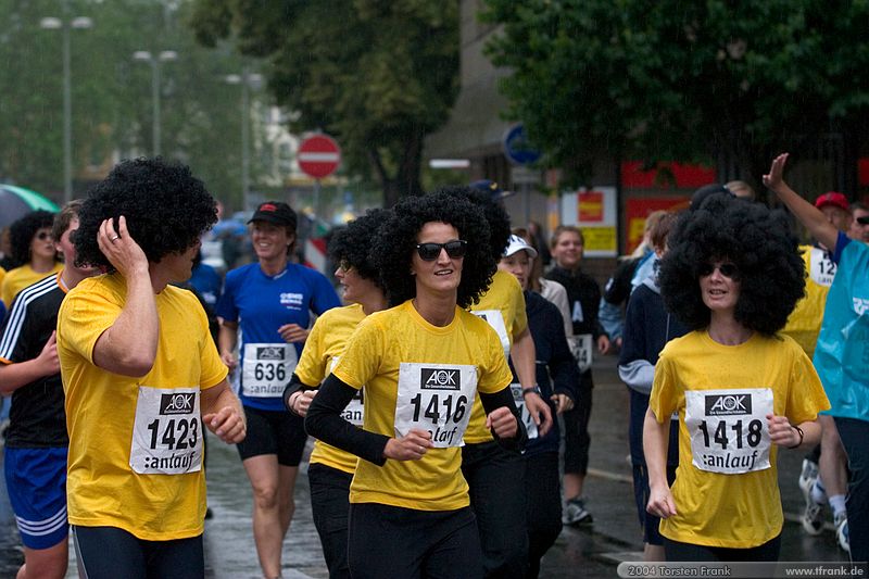 Laufteilnehmer der Gemeinde Neunkirchen, Team "Irrläufer"\n1. Siegerländer AOK – Firmenlauf am 9. Juli 2004 in der Siegener Innenstadt über 5,5 km mit über 2200 gemeldeten Teilnehmern. Die Witterungsbedingungen mit teilweise strömenden Regen und zurückhaltenden Temperaturen waren leider nicht dem sommerlichen Datum angemessen, was der Lauffreude jedoch keinen Abbruch tat.