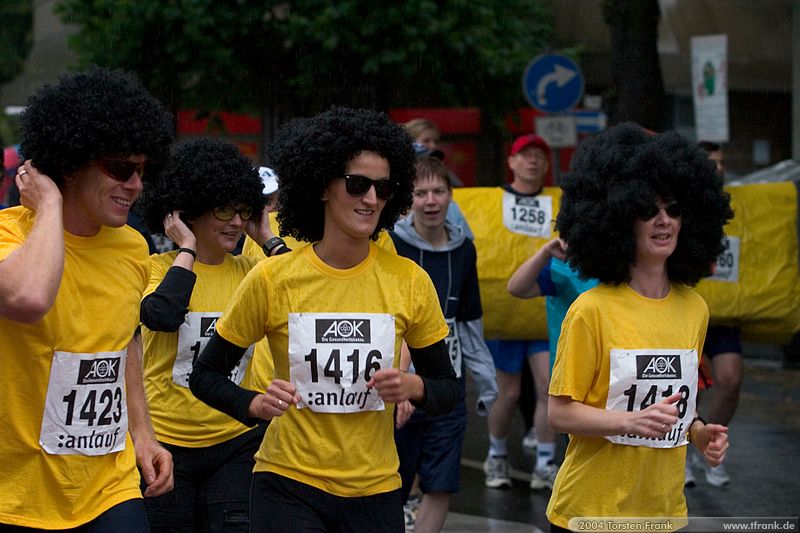 Laufteilnehmer der Gemeinde Neunkirchen, Team "Irrläufer"\n1. Siegerländer AOK – Firmenlauf am 9. Juli 2004 in der Siegener Innenstadt über 5,5 km mit über 2200 gemeldeten Teilnehmern. Die Witterungsbedingungen mit teilweise strömenden Regen und zurückhaltenden Temperaturen waren leider nicht dem sommerlichen Datum angemessen, was der Lauffreude jedoch keinen Abbruch tat.