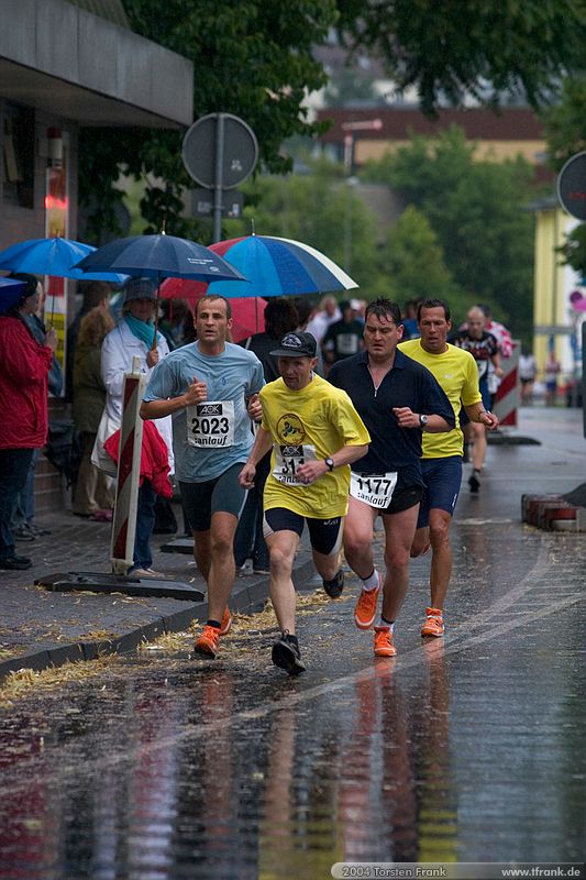 Weit vorn liegende Läufer am Ende der ersten Runde.\n1. Siegerländer AOK – Firmenlauf am 9. Juli 2004 in der Siegener Innenstadt über 5,5 km mit über 2200 gemeldeten Teilnehmern. Die Witterungsbedingungen mit teilweise strömenden Regen und zurückhaltenden Temperaturen waren leider nicht dem sommerlichen Datum angemessen, was der Lauffreude jedoch keinen Abbruch tat.