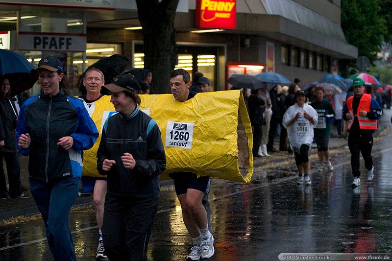 Ein zusammengeschweisstes Zweierteam der Röhrenwerk Gebr. Fuchs GmbH, rechts im Hintergrund Volker.\n1. Siegerländer AOK – Firmenlauf am 9. Juli 2004 in der Siegener Innenstadt über 5,5 km mit über 2200 gemeldeten Teilnehmern. Die Witterungsbedingungen mit teilweise strömenden Regen und zurückhaltenden Temperaturen waren leider nicht dem sommerlichen Datum angemessen, was der Lauffreude jedoch keinen Abbruch tat.