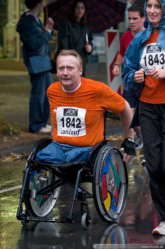 Ein Teilnehmer des Teams "Run & Roll Rathaus Wilnsdorf"\n1. Siegerländer AOK – Firmenlauf am 9. Juli 2004 in der Siegener Innenstadt über 5,5 km mit über 2200 gemeldeten Teilnehmern. Die Witterungsbedingungen mit teilweise strömenden Regen und zurückhaltenden Temperaturen waren leider nicht dem sommerlichen Datum angemessen, was der Lauffreude jedoch keinen Abbruch tat.